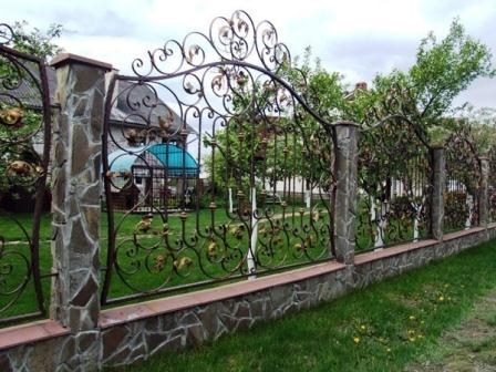 Приятный кованый забор с каменным столбом